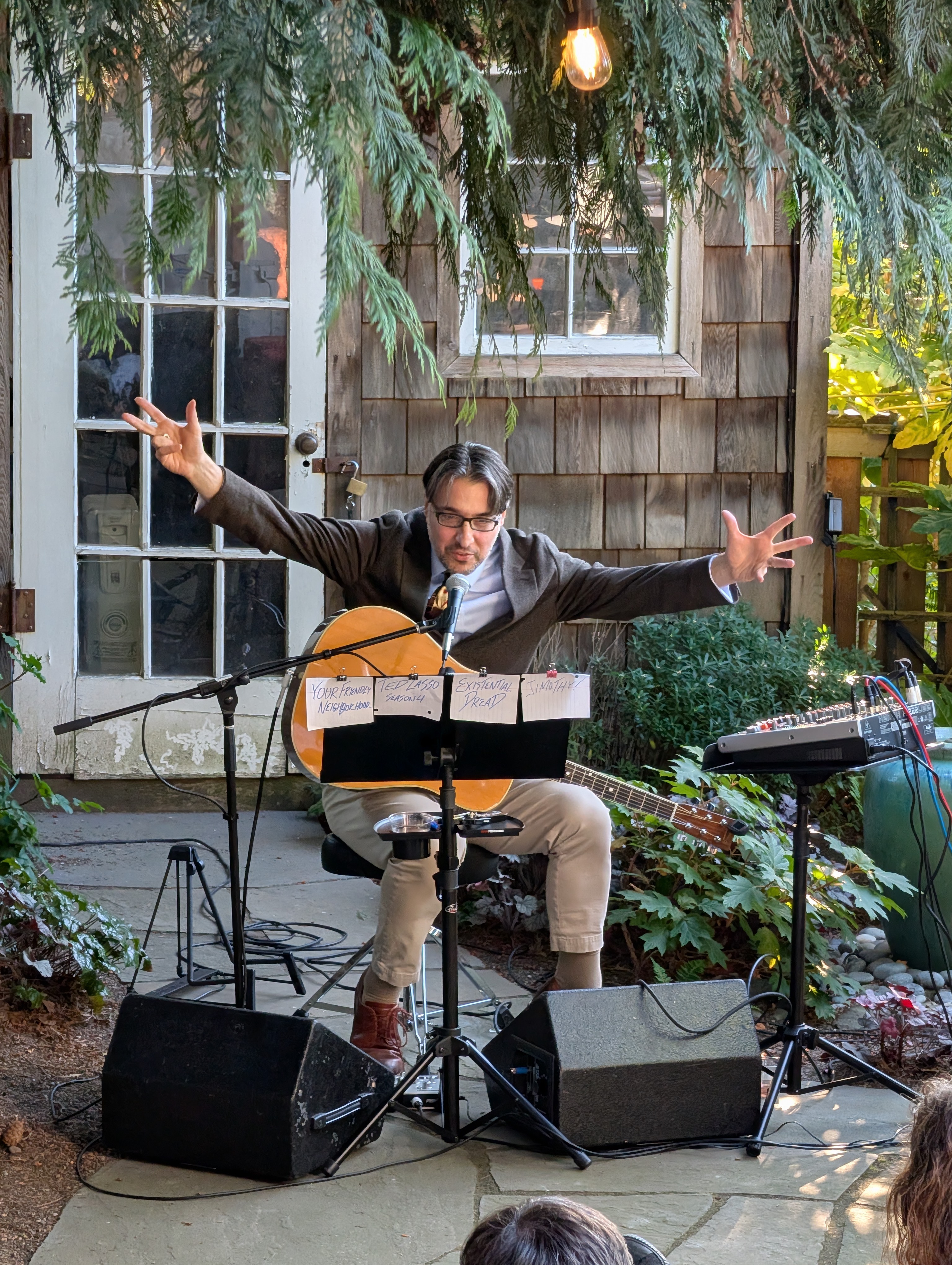 Performing with guitar and mic, setlist on stand
